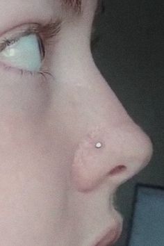 a close up of a person's nose and nose piercing