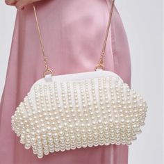 This quirky clutch will add a touch of whimsy to any outfit. With intricate beading and a playful design, the Lydia Beaded Clutch is the perfect accessory for any occasion. Carry your essentials in style and stand out from the crowd with this unique piece. Chic Pearl Clutch For Party, Trendy Beaded Evening Bag, Chic Evening Bag With Pearl Embroidery, Pearl Clutch For Party, Beaded Rectangular Party Clutch, Pearl Embellished Clutch, Pearl White Clutch For Parties, Pearl Embellished Evening Bag For Party, Chic Pearl Evening Bag