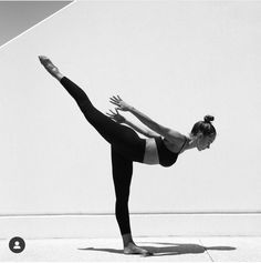 a woman in black and white doing a yoga pose