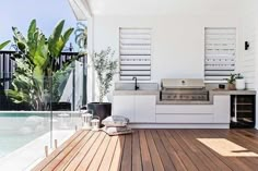 an outdoor kitchen with wood floors and white walls