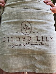 a person holding a bag with the words gilded lily on it