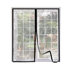 an open window with the curtains pulled back to reveal a view of a garden outside