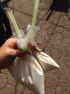 a person holding two plastic bags with green handles and one white bag containing three candles