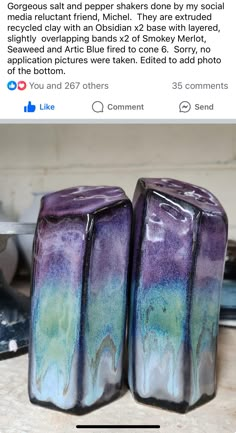 two purple and green vases sitting on top of a table