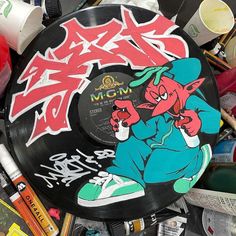 a record covered in graffiti sitting on top of a pile of other items and supplies