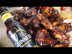 a bottle of guinness beer next to some chicken wings