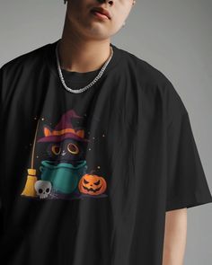 a man wearing a black t - shirt with an image of a cat in a witches hat