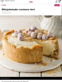 a cake with white frosting and sprinkles on it sitting on a plate