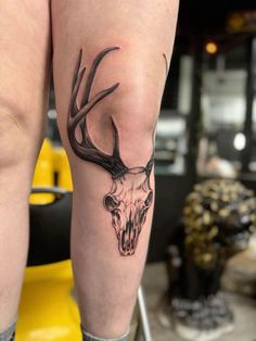 a woman's leg with a deer skull and antelope tattoo on it