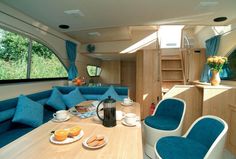 the interior of a camper with blue couches and tables in front of it