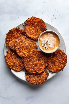 some food is sitting on a plate and ready to be eaten with sauce in the bowl