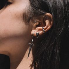 a close up of a person with ear piercings on their ears and behind the ear