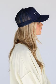 a woman wearing a white shirt and blue hat with the word hl on it