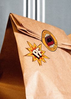 a brown paper bag with stickers on it