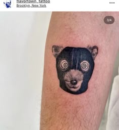 a man's arm with a small bear tattoo on it