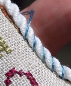 someone is stitching on the side of a piece of fabric