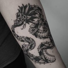 a black and white photo of a dragon tattoo on the arm