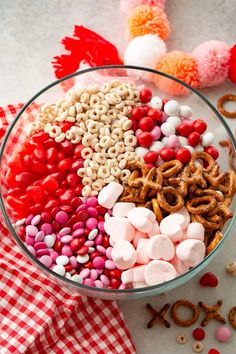 a bowl filled with candy and pretzels on top of a checkered table cloth