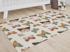 a white rug with colorful butterflies on it in a room next to a crib