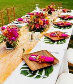 a long table is set with plates and place settings for an outdoor dinner or party