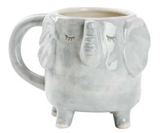 an elephant shaped mug with eyes closed and eyelashes on it's face, sitting in front of a white background