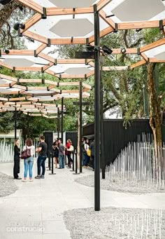 many people are standing under umbrellas on the sidewalk