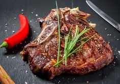 a piece of steak on a cutting board next to a knife and pepper