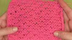 two hands holding a pink crocheted piece of cloth