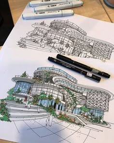 a drawing of a building on top of a table with markers and pencils next to it