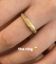 a close up of a person's hand with a gold ring on their finger