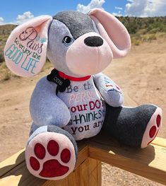 a stuffed animal sitting on top of a wooden fence