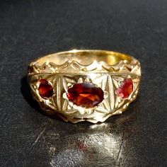 Capture a beautiful moment with this 18K Yellow Gold Plated Silver Garnet three-stone Band Ring. Handmade with natural gemstones, this unique jewelry is a daring addition to your collection. Size 10.25, but can be resized - go bold and add a special sparkle! METAL : .925 Sterling Silver + gold plated STONE: natural Garnet SIZE: US 10.25 *for other sizes pease leave a message after order. Garnet Ring Gold, Garnet Gem, Men Rings, Garnet Ring, Red Band, Signet Rings, Garnet Rings, Men's Rings, Jewelry Inspo