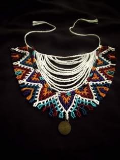 a multicolored beaded necklace on a black background