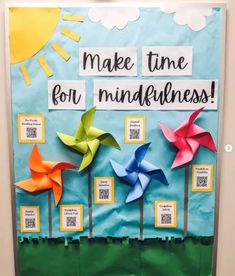 a bulletin board with four pinwheels and the words make time for mindfulness