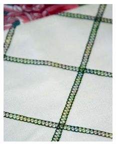 a close up view of a white and red blanket with green lines on the edges