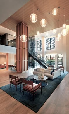 a living room filled with furniture and lots of lights hanging from the ceiling next to a stair case