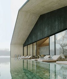 an empty swimming pool next to a large building with glass windows on the outside and inside