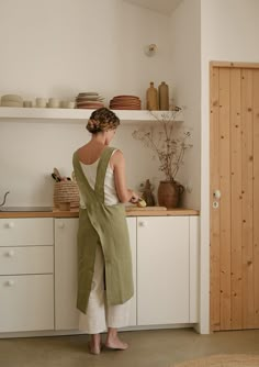 a woman is standing in the kitchen preparing food