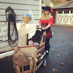 a woman dressed up as a pirate pulling a cart with items on the front and back