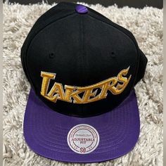 To Play Up Your Unique Style, Mitchell & Ness Has Made This Decorated Snapback Hat. Mitchell & Ness Grand Logo Above Snapback Opening. Los Angeles Lakers. This Cap Features Lakers Team Logo Embroidered Front Lakers Team, Mitchell & Ness, Los Angeles Lakers, Hat Cap, Purple Black, Snapback Hat, Logo Embroidered, Snapback Hats, Purple And Black