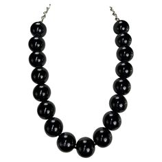 Presenting a beautiful black beaded Gianni Versace necklace, designed by Gianni Versace. From the late 1980s, this necklace features a strand of large black beads and is complete with a silver-tone chain closure. From the early days of Gianni's namesake brand, this classic necklace is the perfect addition to any wardrobe. Approximate measurements: Total length: 27" Diameter beads: 1" Formal Black Beaded Chain Necklace, Black Beaded Necklace For Formal Costume Jewelry, Formal Black Necklace With Beaded Chain, Formal Black Beaded Costume Jewelry Necklace, Formal Black Beaded Costume Necklace, Black Single Strand Beaded Necklaces For Party, Black Single Strand Beaded Necklace For Party, Party Black Single Strand Beaded Necklace, Black Beaded Costume Jewelry Necklace For Formal Occasions