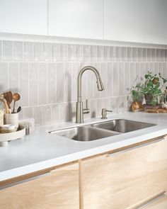 a kitchen sink with wooden cabinets and white counter tops next to a dishwasher