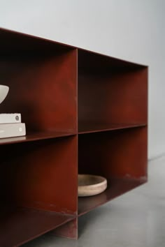 a shelf that has some books on top of it and a bowl in the middle