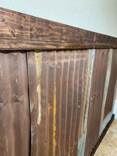 a close up of a wooden fence with rusted metal strips on the top and bottom