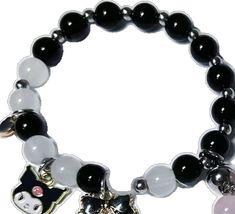 a black and white beaded bracelet with a cat charm on the front, and a silver plated kitty charm on the back