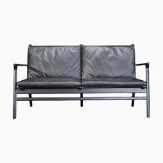 a black leather couch sitting on top of a metal frame