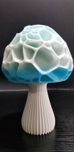 a white and blue mushroom sitting on top of a table