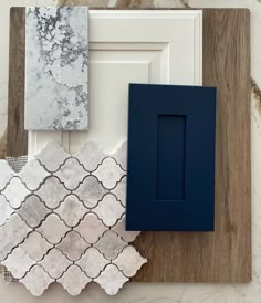 various tile samples are displayed on a wooden board with white and blue trimmings