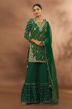 Green bandhani pattern kurta with floral gota work. Paired with tiered sharara and ruffle dupatta.
Components: 3
Pattern: Embroidered
Type Of Work: Floral
Neckline: Round
Sleeve Type: Long
Fabric: Kurta and Sharara: Georgette, Dupatta: Chiffon
Color: Green
Other Details: 
Weight (in gms): 850
Gota work
Tassel tie-ups
Occasion: Work - Aza Fashions Sharara Set For Women, Bandhani Dress Salwar Kameez, Bandhani Dress Pattern, Jaipuri Suits, Bandhani Pattern, Kurta And Sharara, Ruffle Dupatta, Sharara Designs, Kurta Sharara Set