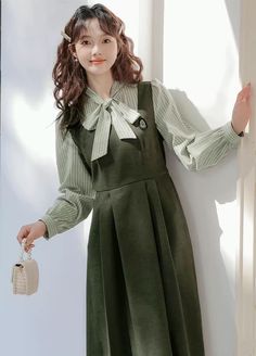 Faux two-piece layered dress with a stripe blouse with two buttons and a tie-up neckline, and a solid colored pinafore dress with a varsity embroidered badge, elastic waist and waist ties. S: 35.5" chest, 27" waist, 42" lengthM: 37" chest, 28.5" waist, 42" lengthL: 38.5" chest, 30" waist, 42" length Pretty Gowns, Women Things, Stripe Blouse, Old Fashion Dresses, A Level, Paint Color Palettes, British Outfits, Layered Dress, Dress Well